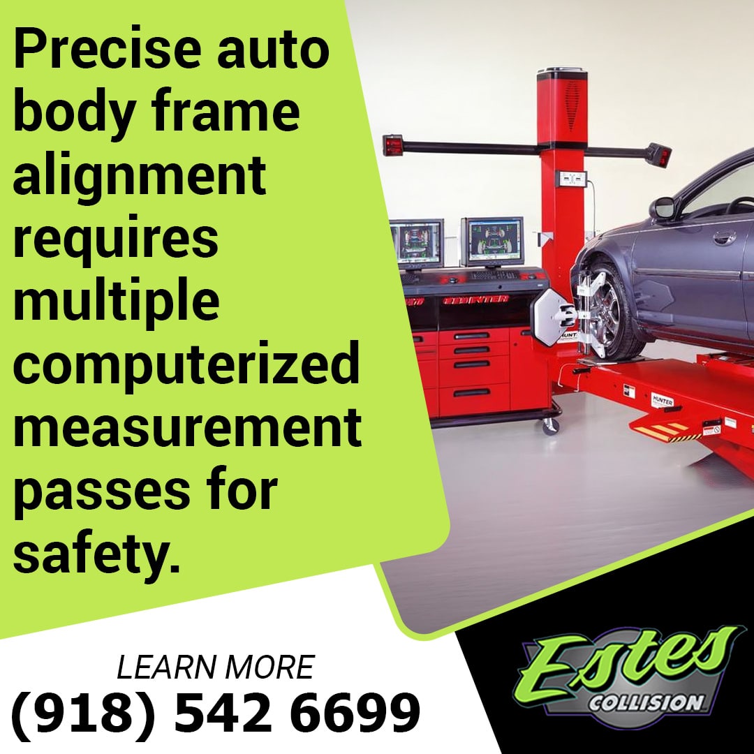Vehicle mounted on a red hydraulic alignment lift undergoing precision computerized measurement with specialized wheel sensors and dual monitor displays.