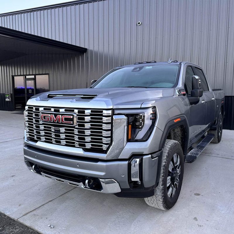 Silver GMC truck parked outside building